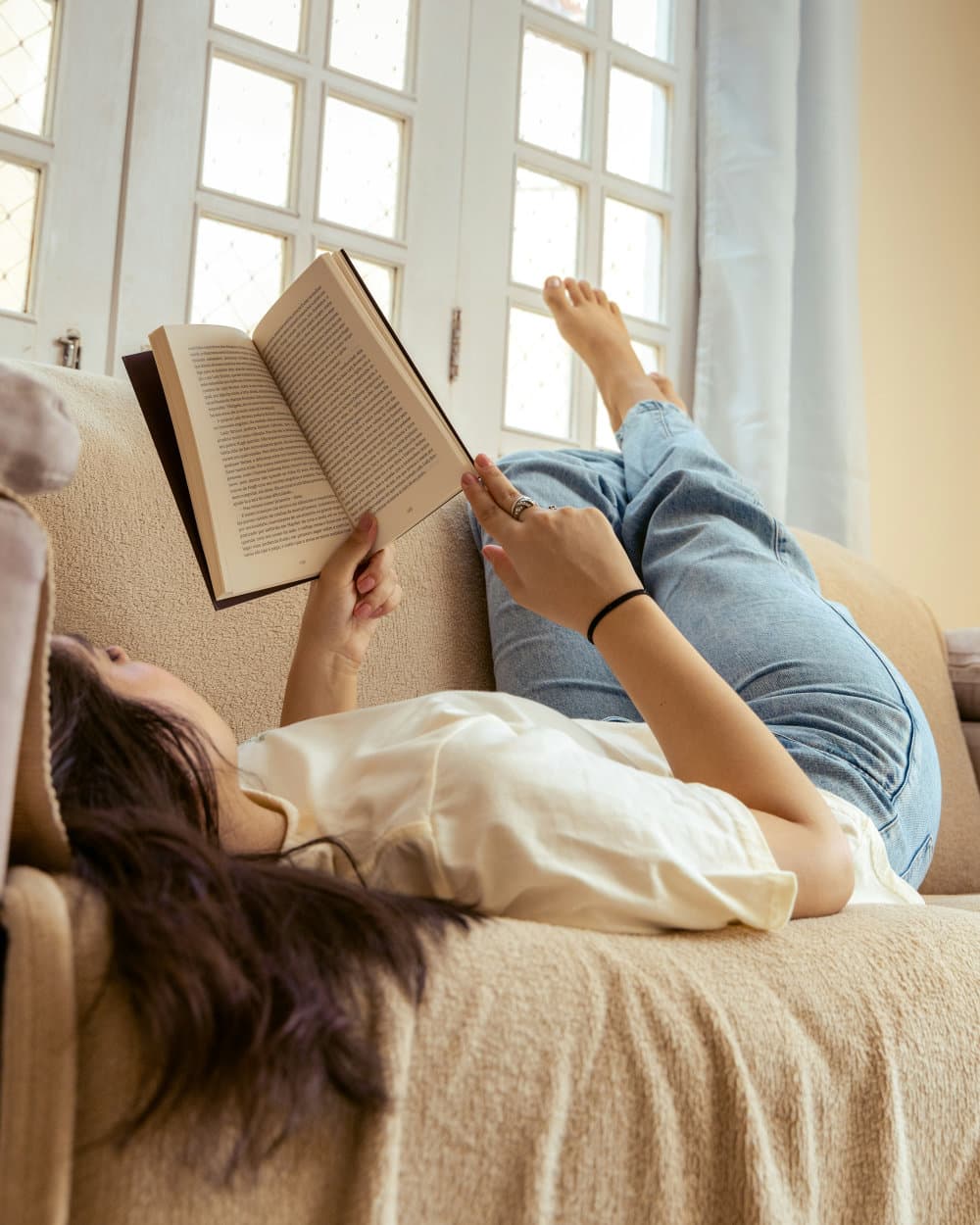 A woman lying back on a couch, completely at ease